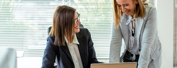 Zwei Kolleg*innen in einer Besprechung vorm Bildschirm